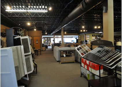 Interior of retail store for home decor items, including furniture and carpet samples.
